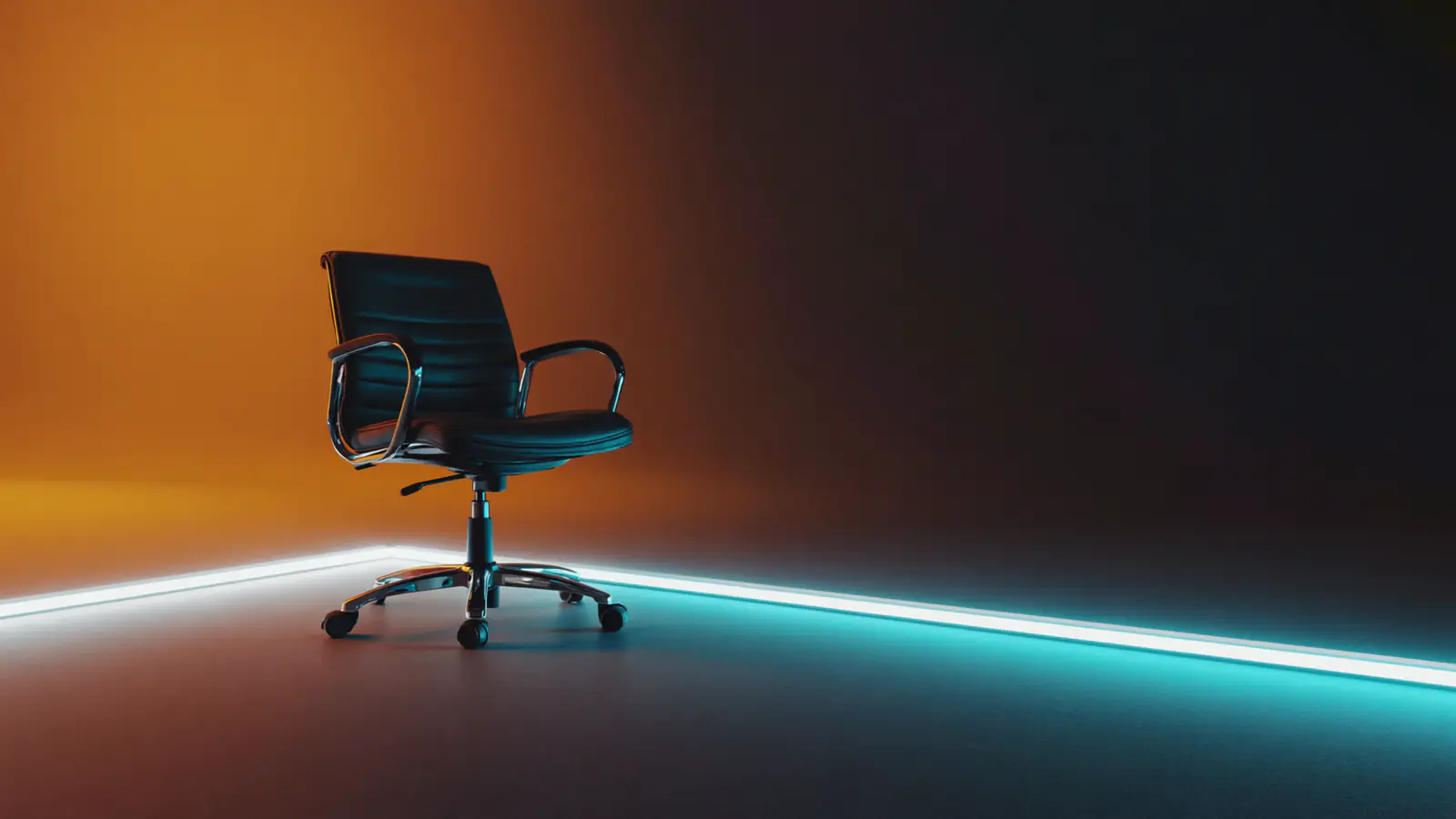 An empty office chair in the dark, one shaft of amber light across the seat