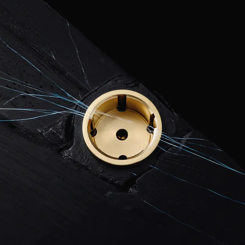 A brass keyway socket set into black metal, gold light pouring out of the opening